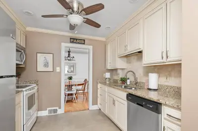 a kitchen with white cabinets and a ceiling fan at Charming Cottage | Near I-75 & Horse Park + Farms in Lexington