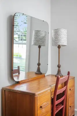 a desk with a mirror and a lamp on it at Charming Cottage | Near I-75 & Horse Park + Farms in Lexington