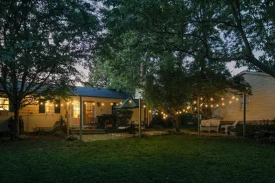 a house with christmas lights in the yard at night at Charming Cottage | Near I-75 & Horse Park + Farms in Lexington