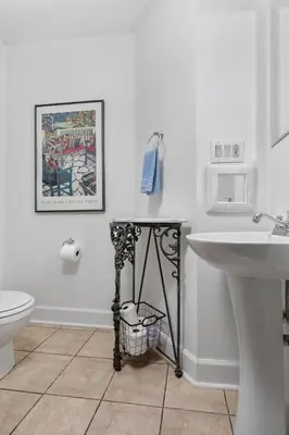 a white bathroom with a sink and a toilet at Charming Cottage | Near I-75 & Horse Park + Farms in Lexington