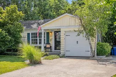 a small house with an american flag in front of it at Charming Cottage | Near I-75 & Horse Park + Farms in Lexington