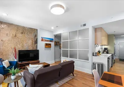 a living room with a couch and a tv and a kitchen at OTR - Court Street Entertainment District Cincinnati in Cincinnati