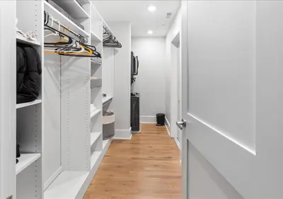 a walk in closet with white walls and wooden floors at OTR - Court Street Entertainment District Cincinnati in Cincinnati