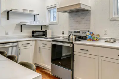 a kitchen with white cabinets and a stove top oven at Walk to Marshall University Home with Private Yard! in Huntington