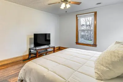 a bedroom with a bed and a flat screen tv at Walk to Marshall University Home with Private Yard! in Huntington