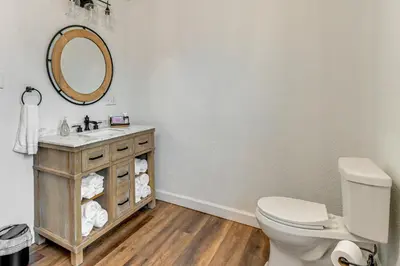 a bathroom with a toilet and a sink and a mirror at Walk to Marshall University Home with Private Yard! in Huntington