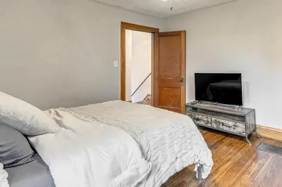 a bedroom with a bed and a flat screen tv at Walk to Marshall University Home with Private Yard! in Huntington