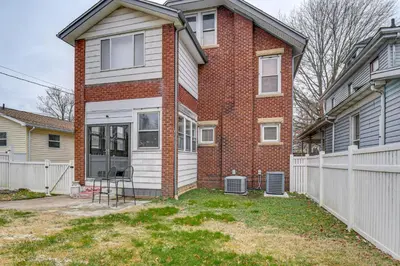a brick house with a white fence in a yard at Walk to Marshall University Home with Private Yard! in Huntington