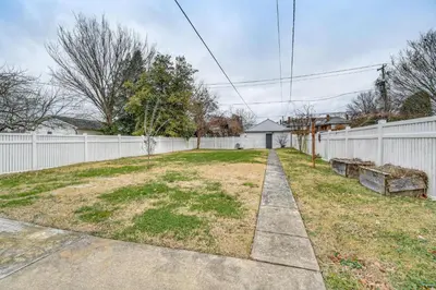 a backyard with a white fence and a sidewalk at Walk to Marshall University Home with Private Yard! in Huntington