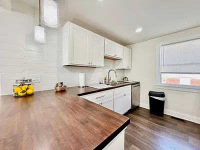 a kitchen with white cabinets and a wooden counter top at Cute and Cozy House in Quiet Blue Ash Neighborhood in Blue Ash