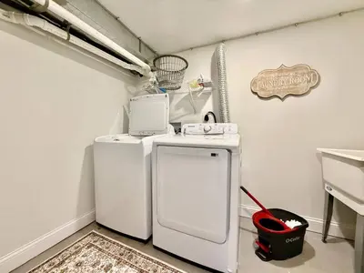 a small kitchen with a white refrigerator and a bucket at Cute and Cozy House in Quiet Blue Ash Neighborhood in Blue Ash