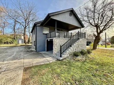 a small house with a balcony on a street at Cute and Cozy House in Quiet Blue Ash Neighborhood in Blue Ash