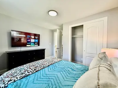 a bedroom with a bed and a flat screen tv at Cute and Cozy House in Quiet Blue Ash Neighborhood in Blue Ash