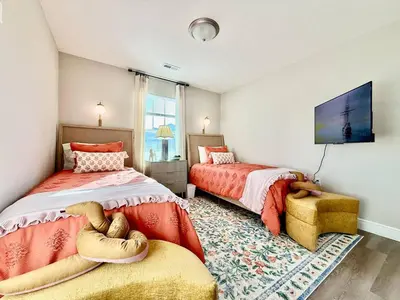 a bedroom with two beds and a tv and a chair at Cozy Equestrian Themed Getaway in Wilmington in Wilmington