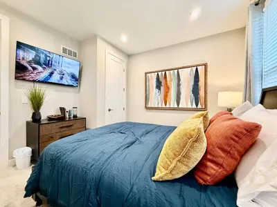 a bedroom with a blue bed with orange pillows at Stunning Executive Townhome Liberty Twp in Wetherington
