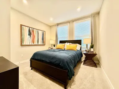 a bedroom with a large bed and a window at Stunning Executive Townhome Liberty Twp in Wetherington