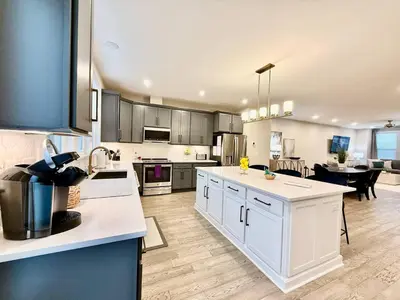 a large kitchen with white cabinets and a dining room at Stunning Executive Townhome Liberty Twp in Wetherington