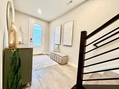 a living room with a staircase and a chair at Stunning Executive Townhome Liberty Twp in Wetherington