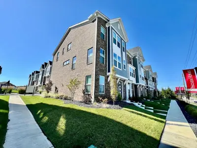 a large apartment building with a grass yard at Stunning Executive Townhome Liberty Twp in Wetherington