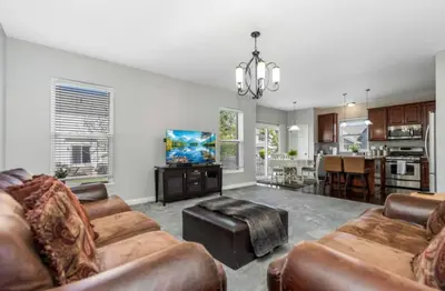 a living room with two couches and a kitchen at Modern 4BR Columbus Home Near Airport in Columbus