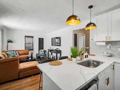 a kitchen and a living room with a couch at Comfortable 3BR home with workspace & parking in Parma