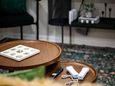 a table with two wii remotes and two remote controls at Comfortable 3BR home with workspace & parking in Parma