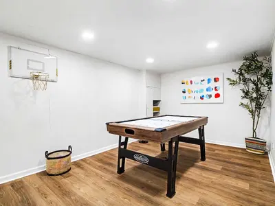 a ping pong table in a room with a basketball hoop at Comfortable 3BR home with workspace & parking in Parma