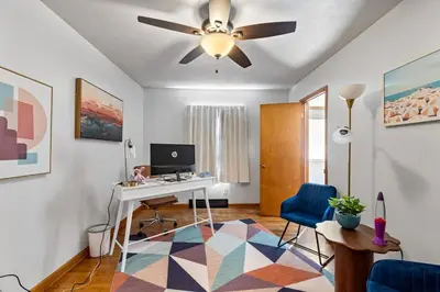a living room with a desk and a ceiling fan at Akron in Akron