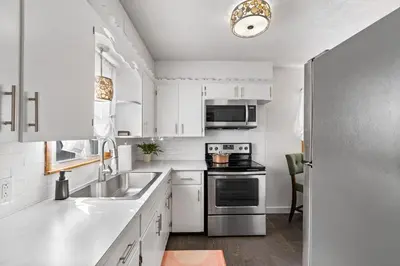 a kitchen with white cabinets and a stainless steel refrigerator at Akron in Akron