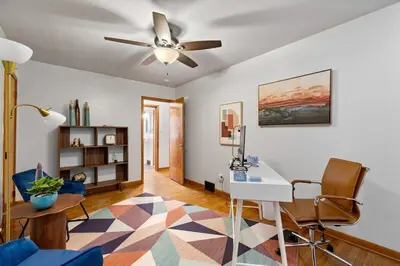 a living room with a desk and a ceiling fan at Akron in Akron