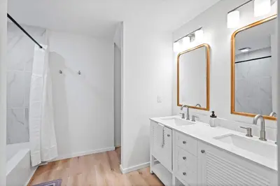 a white bathroom with two sinks and a shower at Rivers Edge Retreat For 10ppl in Dayton