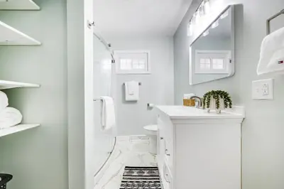 a white bathroom with a shower and a sink at Serenity on Sanford in Portsmouth