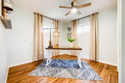 a dining room with a table and a ceiling fan at Serenity on Sanford in Portsmouth