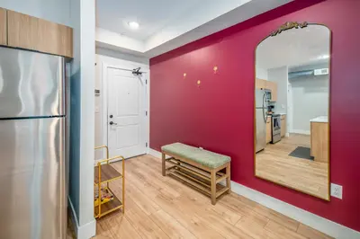 a living room with a red wall and a mirror at OTR 1BR by TQL, Sleeps 4ppl, Lux King Bed, Wifi, 4th Fl in Cincinnati