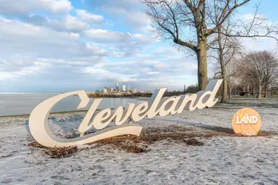 a sign on the beach with the city in the background at 6 Mi to Downtown Cleveland Lakeview Condo! in Lakewood