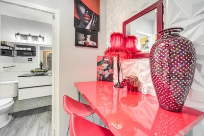 a red dining room table with a vase and red chairs at 6 Mi to Downtown Cleveland Lakeview Condo! in Lakewood