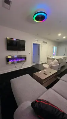 a living room with a couch and a tv on the wall at The 513 Flat 2! 1BR, 1Bath Apt with Pool and Riverfront View! Free Gated Parking! Only Steps from The banks & Stadiums! in Cincinnati