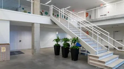 a staircase in a building with potted plants at The 513 Flat 2! 1BR, 1Bath Apt with Pool and Riverfront View! Free Gated Parking! Only Steps from The banks & Stadiums! in Cincinnati