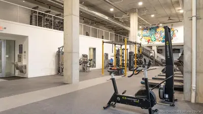 a gym with treadmills and ellipticals in a building at The 513 Flat 2! 1BR, 1Bath Apt with Pool and Riverfront View! Free Gated Parking! Only Steps from The banks & Stadiums! in Cincinnati