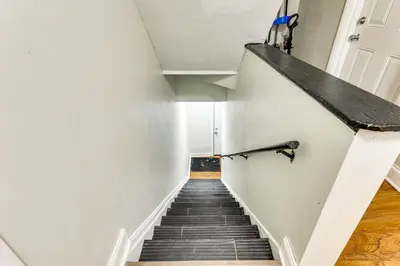 a stairway leading up to a room with white walls at Close to Camden Clark Central Parkersburg Condo in Parkersburg