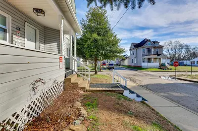 a house with a white fence next to a street at Close to Camden Clark Central Parkersburg Condo in Parkersburg