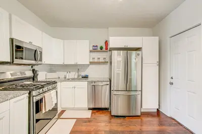 a kitchen with white cabinets and a stainless steel refrigerator at Quiet & Spacious Home Near Downtown in Columbus