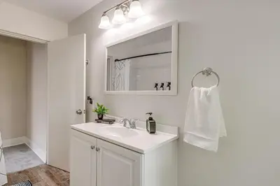 a white bathroom with a sink and a mirror at Quiet & Spacious Home Near Downtown in Columbus