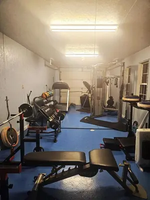 a gym with several tread machines in a room at Secluded one room house on 235 acres in Salem