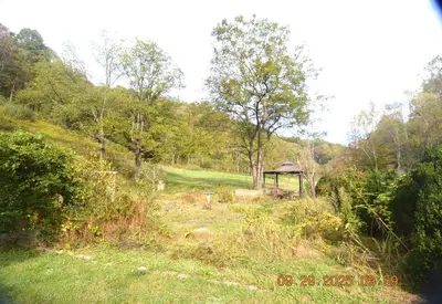 a gazebo in the middle of a field with trees at Secluded one room house on 235 acres in Salem
