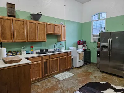 a kitchen with wooden cabinets and a stainless steel refrigerator at Secluded one room house on 235 acres in Salem