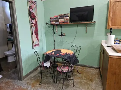 a kitchen with a table and two chairs and a tv at Secluded one room house on 235 acres in Salem