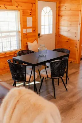 a dining room with a black table and chairs at Cedar Wrapped Cozy Villa Cabin - 4 miles from Trails in Laurelville