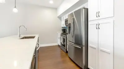 a kitchen with a stainless steel refrigerator and white cabinets at Landing Spectacular 2BD Gym in Cleveland