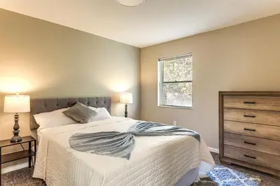 a bedroom with a bed with a dresser and a window at 6 Mi to Downtown Cincy Group-Friendly Townhome! in Cincinnati